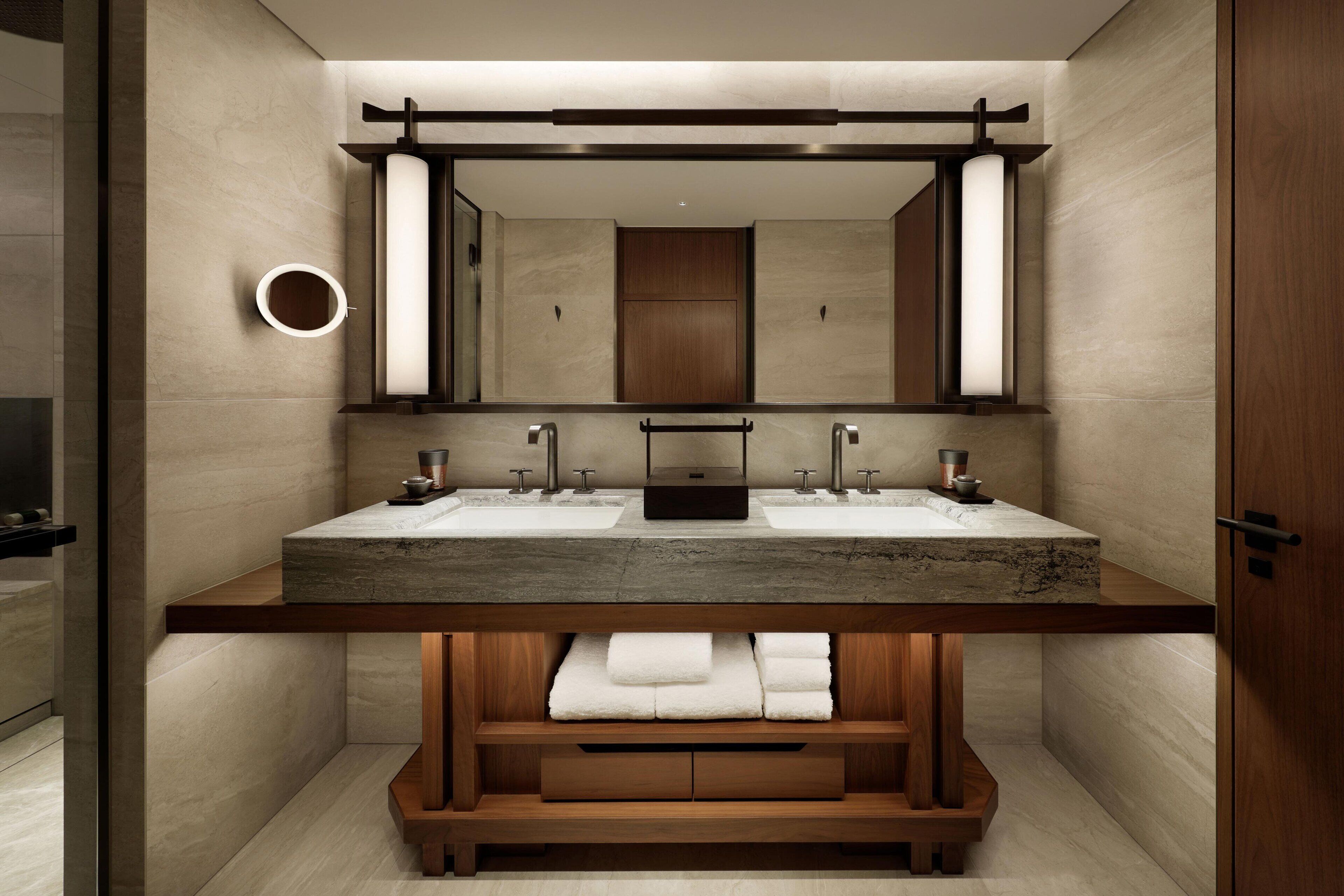 Een moderne badkamer met twee wastafels, een grote spiegel en een houten wastafelmeubel.