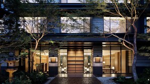 A modern building with a large entrance, a stone lantern, and a well-lit interior visible through the doors. - HOTEL THE MITSUI KYOTO, a Luxury Collection Hotel & Spa (Kyoto)