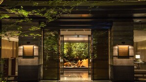 A hotel entrance with a glass door, framed by stone pillars, and a sign above the door. - HOTEL THE MITSUI KYOTO, a Luxury Collection Hotel & Spa (Kyoto)
