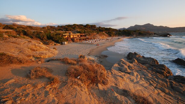 Un hôtel situé en bord de mer, doté d’une terrasse donnant sur l’océan, d’une plage de sable et d’un terrain rocheux.