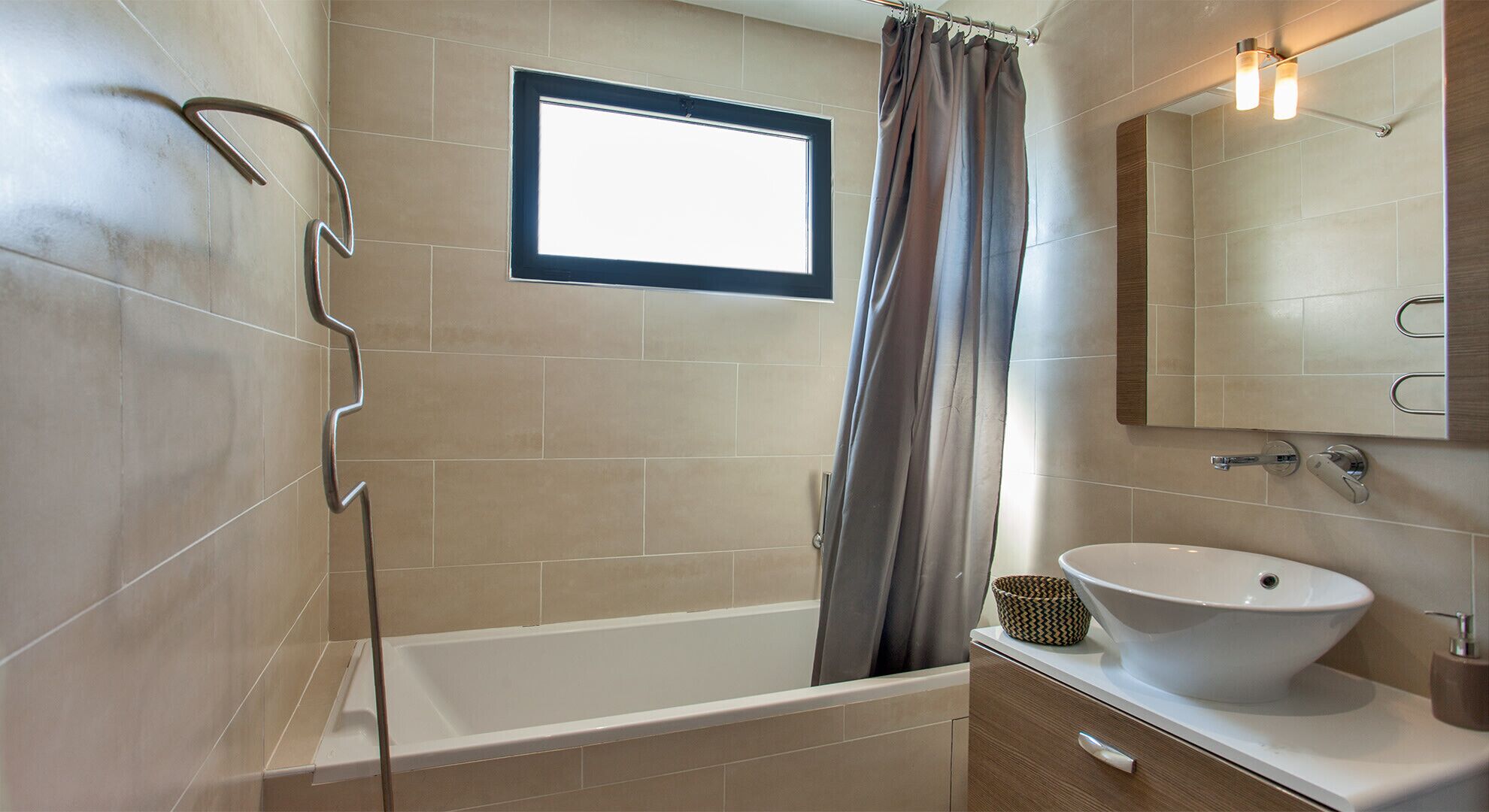 A modern bathroom with a bathtub, a sink, and a window.