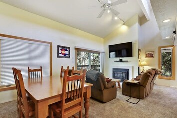 Living room with gas fireplace, mounted TV, and balcony