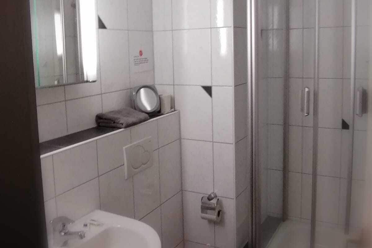 A bathroom with a sink, toilet, and a glass-enclosed shower.