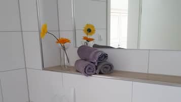 Ein Badezimmer mit einem weißen Waschbecken, einem Holz-Waschtisch, einer Toilette und einem Spiegel über dem Waschbecken.