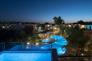 A resort with a large infinity pool, outdoor seating, and a view of the surrounding landscape. - Okeanis Golden Resort (Chania)