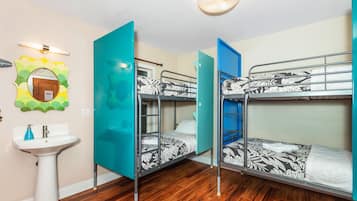 A room with bunk beds, a sink, and a mirror.