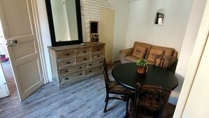 A dining area with a wooden table and chairs, a small potted plant, and a mirror on the wall. - Private mansion (Béziers)