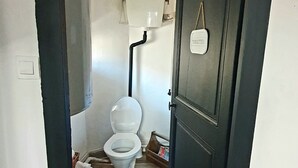 A narrow hallway leading to a bathroom with a toilet, a small table with a tissue box, and a door labeled "TOILETTES". - Private mansion (Béziers)