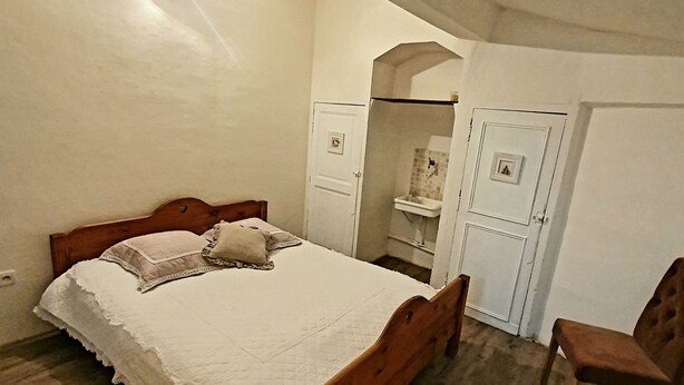 A bedroom with a wooden bed, a chair, and a wardrobe. - Private mansion (Béziers)