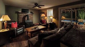 A cozy living room with a fireplace, leather furniture, and a pool table. - Base Camp One! Hot Tub Pool Table Pet Friendly (Cherry Log)