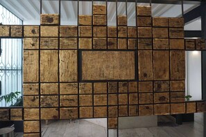 Exposed brick-inspired wall with a grid pattern, supported by a metal framework.
