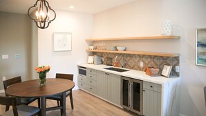 Una cocina moderna con una mesa de comedor redonda, armarios empotrados y una lámpara colgante.