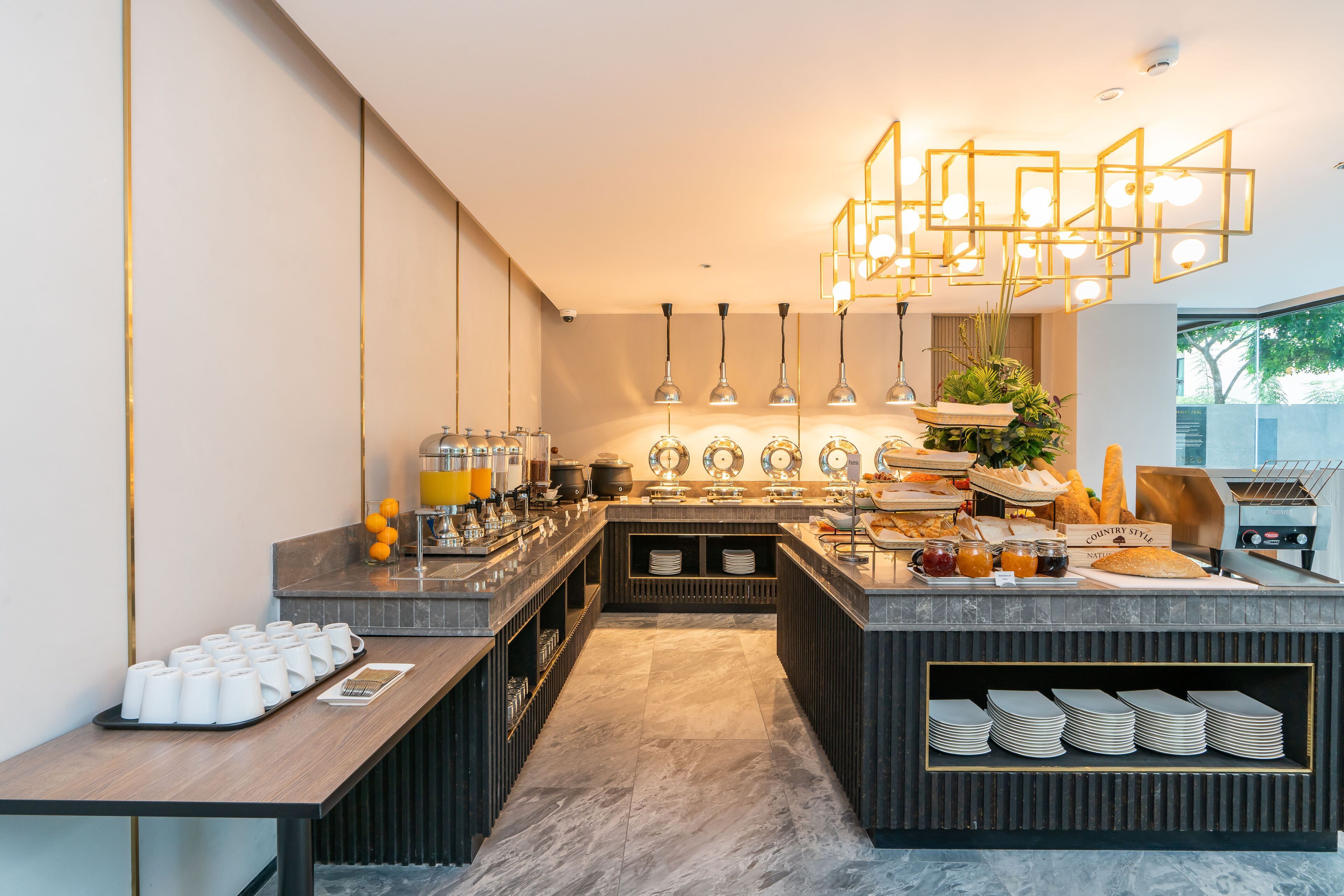 A modern breakfast bar with a variety of food items and a unique geometric light fixture.