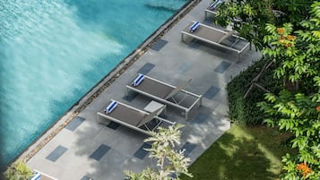 An aerial view of a poolside area with lounge chairs and a tiled deck.