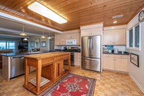 A modern kitchen with wooden cabinets, stainless steel appliances, and a central island.