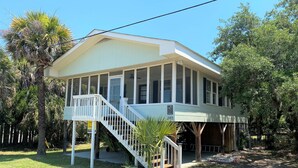 A two-story house with a covered porch and a staircase leading to the upper level. - Pet Friendly Cottage w/ Screened Porch & Easy Beach Access: WiFi Access (Edisto Beach)