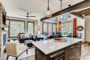 A modern kitchen with a central island, large windows, and a fireplace. - Seasons 1825 (Keystone)