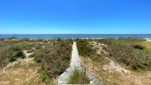 Ein Weg, der zum Strand führt, mit freiem Blick auf das Meer.