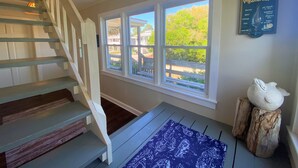 A staircase leading to a landing with a large window and a weather glass on the wall. - Third-Row Home w/ Ocean Views & Easy Beach Access; Screened Porch; Sun Deck; CableTV/WiFi (Edisto Beach)