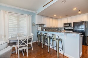 Enjoy cooking in this well-lit kitchen with a central island and bar stools.