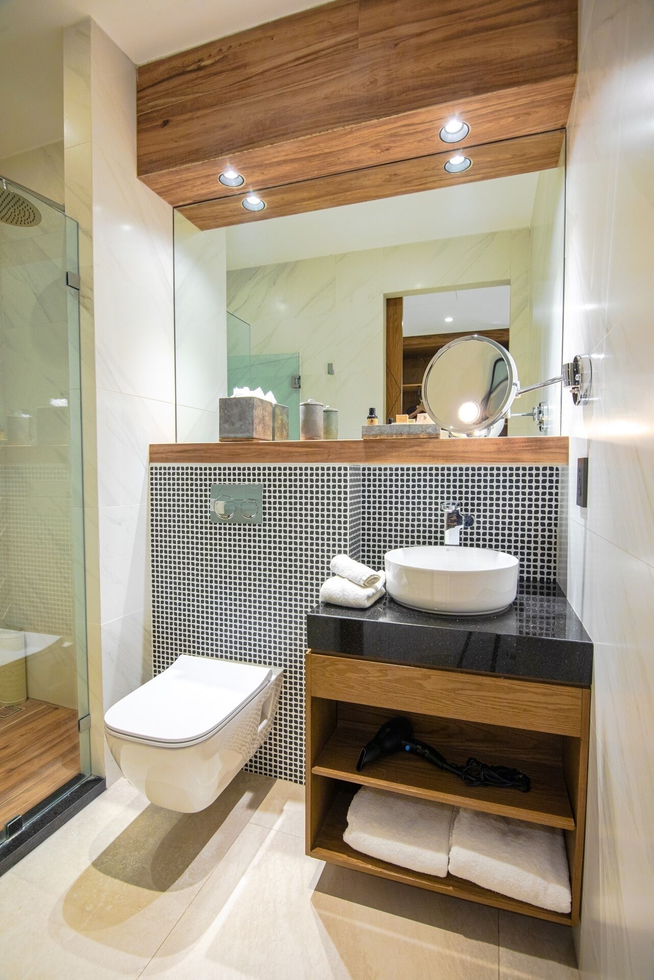 A modern bathroom with a toilet, sink, and shower.