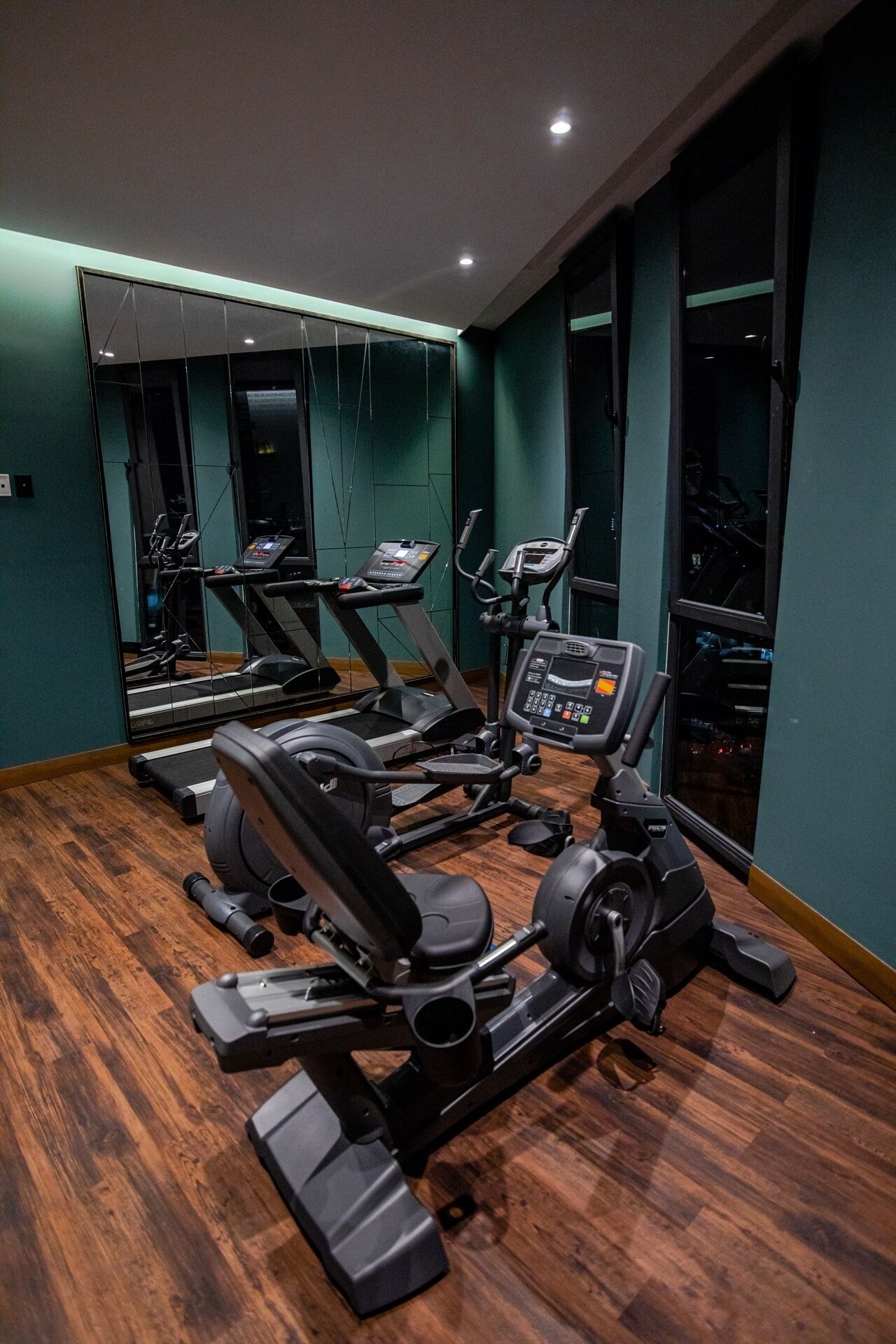 A gym with treadmills, elliptical machines, and stationary bikes.