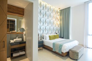 Un dormitorio moderno con una cama grande, un tocador empotrado y un espejo amplio.