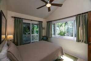 A bedroom with a bed, a ceiling fan, a window with curtains, and a view of greenery outside. - Shrimpers Cove-Waterfront Retreat w/ Private Dock; Pet-Friendly; 3 Blocks from Beach Access (Edisto Beach)