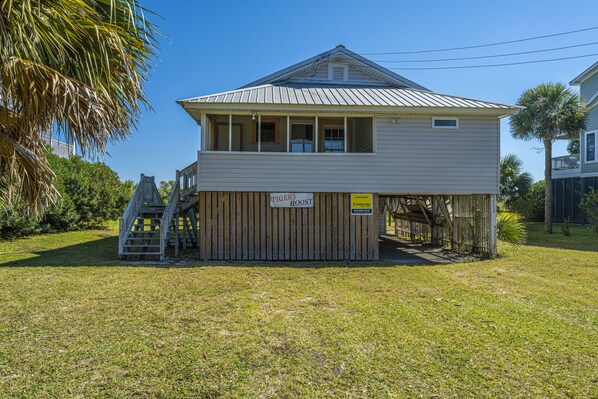 A two-story building with a sign reading "TIGERS ROOST" and a wooden deck.