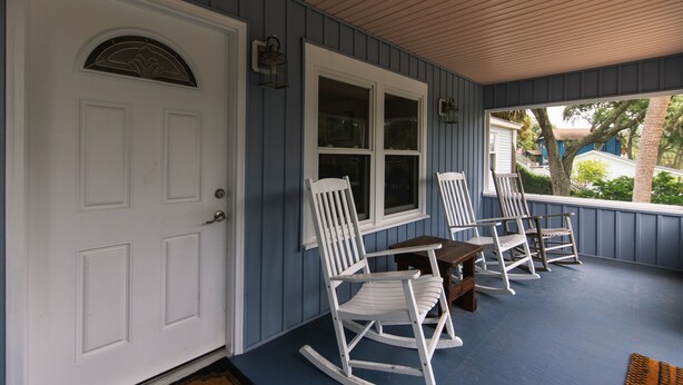 A porch with a white door, a window, and three rocking chairs. - Villa Kunterbunt | Classic Beach Walk Cottage | Screened Porch & Sun Deck | Sleeps 8 | Pet Friendly (Edisto Beach)