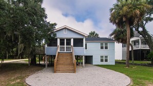 A two-story house with a wooden deck and a staircase leading to the upper floor. - Villa Kunterbunt | Classic Beach Walk Cottage | Screened Porch & Sun Deck | Sleeps 8 | Pet Friendly (Edisto Beach)