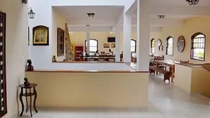 Eine großzügige Lobby mit einer zentralen Theke, großen Fenstern und einer hohen Decke.
