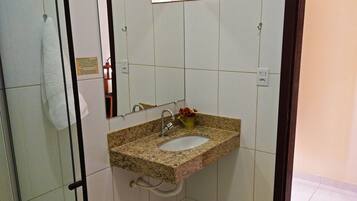 A bathroom with a granite countertop sink, a mirror, and a towel hanging on a rack.