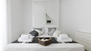 A minimalist bedroom with a bed, pillows, and a bedside table.