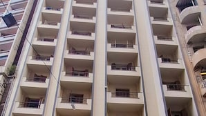 Een hotel met meerdere verdiepingen, elk voorzien van balkons, met een zichtbaar bord voor 'Plaza Olido Hotel' en een winkelpand beneden.