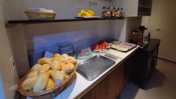 Een buffetopstelling met brood, fruit en diverse etenswaren.