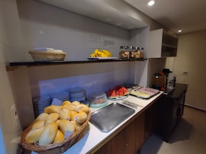 En buffet med brød, frugt og forskellige spisemuligheder.