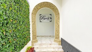 An ornate archway leading to a staircase with a sign reading "Parral 14" by Kachoo.