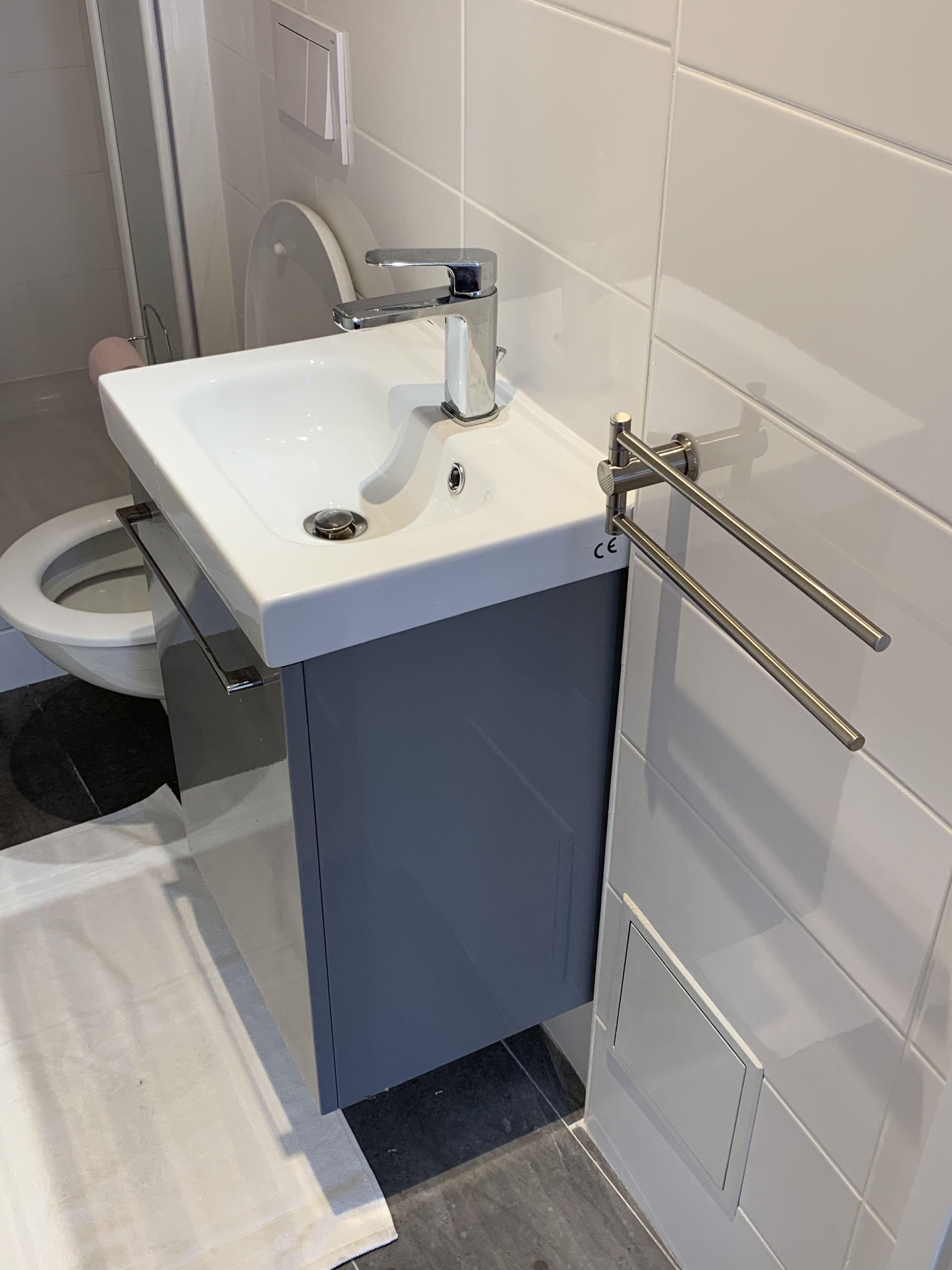 A bathroom with a white sink, a toilet, and a towel rack.