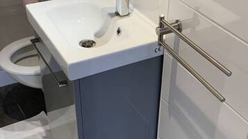 A bathroom with a white sink, a toilet, and a towel rack.