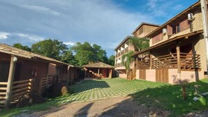 A rustic lodge with wooden cabins and a central building with a balcony. - Pousada do Mica (Imbituba)