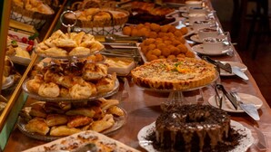 A buffet table with various food items and utensils. - Pousada do Mica (Imbituba)