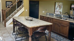 A kitchen with granite countertops, a dining table with chairs, a ceiling fan, and a sign that says "Welcome." - Lake Front Home. Private stairs to private beach and bay. upscale 5 bedroom home (Irving)