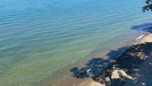 A beach with clear water and a sandy shore. - Lake Front Home. Private stairs to private beach and bay. upscale 5 bedroom home (Irving)