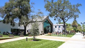 A building with a stone facade, large windows, and outdoor seating areas.