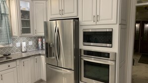 Una cocina moderna con armarios blancos, electrodomésticos de acero inoxidable y un salpicadero con diseño.