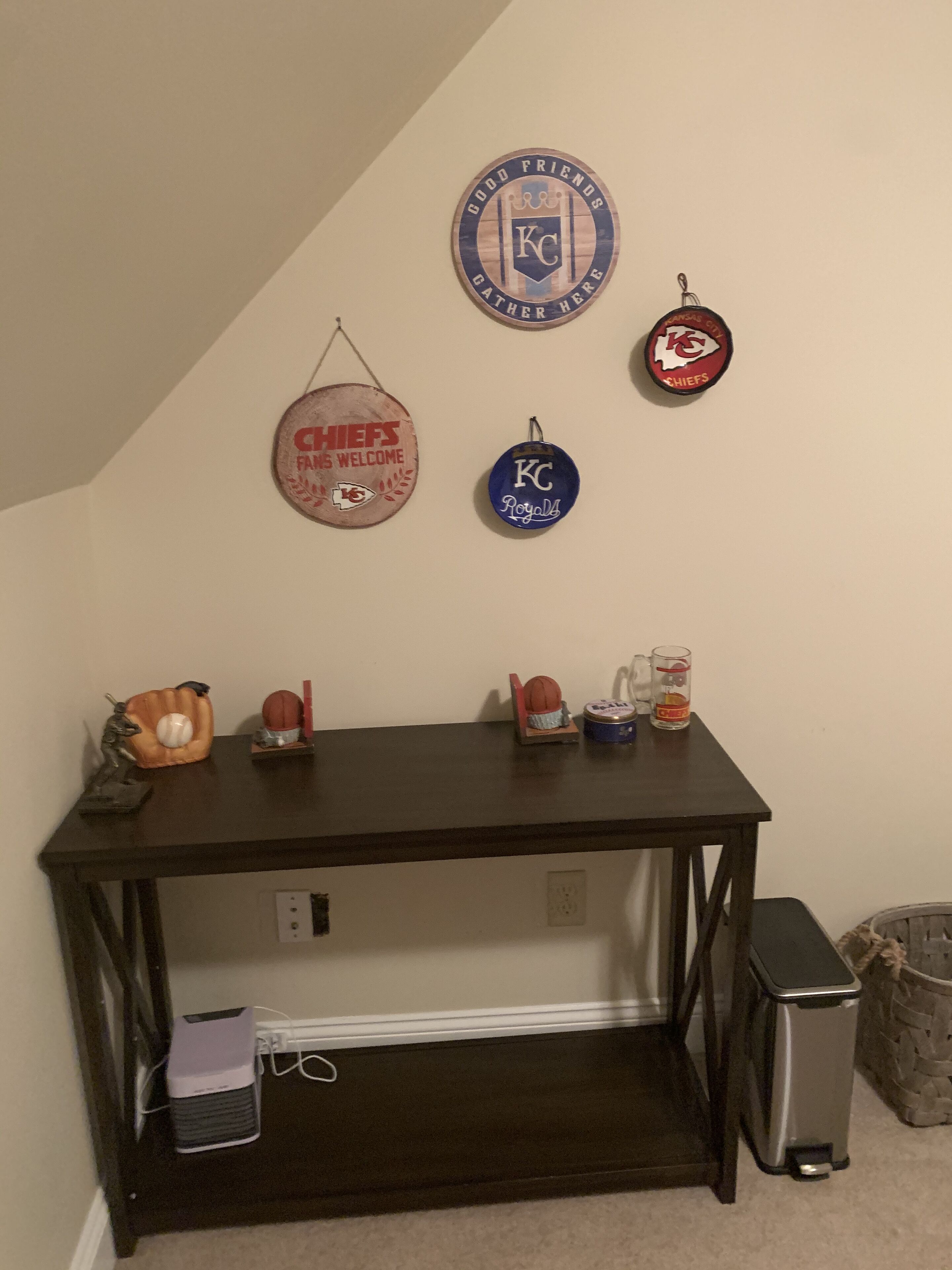 Een kleine, donkere houten tafel met een laptop, een honkbalknuppel en een honkvasthandschoen.