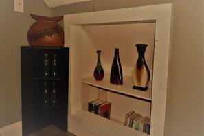 A shelf with decorative vases and a bookcase with books.