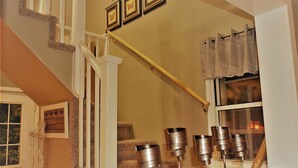 A staircase with a white railing, a wooden handrail, and a window with curtains. - The Bungalow: inviting retreat with a spacious backyard sets for BBQs.  (Grand Forks)
