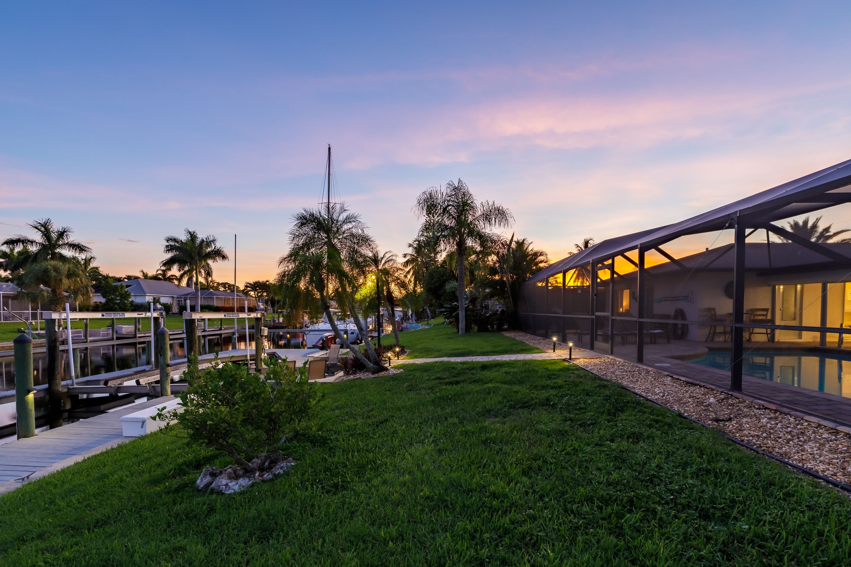 A modern hotel with a pool, a covered outdoor area, and a dock.